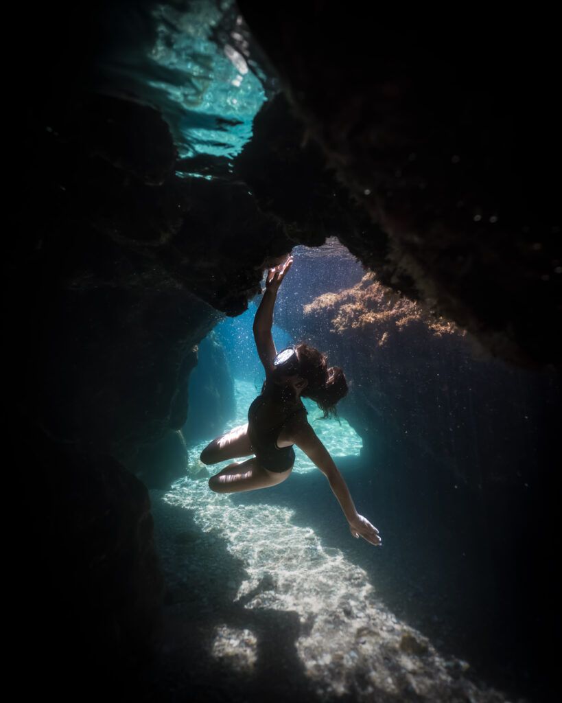 mujer buceando entre rocas